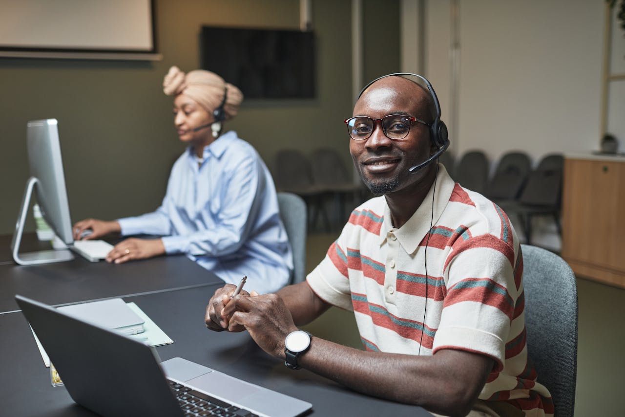 Two call center employees working at desks, focused and collaborative.